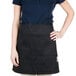 A woman wearing a black Chef Revival bistro apron.