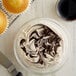 A bowl of caramel-colored frosting with a cupcake on top.