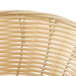 A close up of a Thunder Group round rattan bread basket.