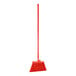 A red broom with long handle and long bristles.