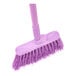 A close-up of the purple Carlisle Sparta Duo-Sweep broom with a handle.