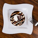 A Fineline white plastic square plate with a chocolate dessert and a white swirl on top served with a fork.