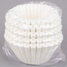 A white plastic bag filled with white coffee filters.