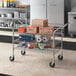 A Regency chrome utility cart with boxes on it.