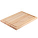 A Nemco wooden carving board with a handle on a table.