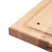 A Nemco wooden carving board with a hole in it.