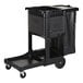 A black Rubbermaid janitor cart with a locking cabinet and attached waste bag.