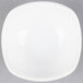 A white square bowl on a gray surface.