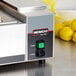 A Nemco 68786 Rocker Switch on a Nemco Countertop Steamer machine with a yellow lemon in a net.