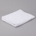 A white folded Oxford Gold Cam bath sheet on a gray surface.