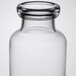 A close-up of a clear glass Libbey Helio water bottle with a round neck.