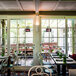 Bromic Heating natural gas outdoor patio heaters above tables and chairs in a farm-to-table restaurant.