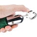 A hand holding a green and silver metal hook.