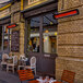 A Bromic Heating black electric patio heater above a table with chairs on a restaurant patio.