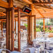 A Bromic Heating natural gas patio heater on a table at a restaurant with white chairs.