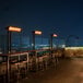 A Bromic black electric patio heater on a metal frame under a table.