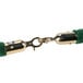 A green Aarco stanchion rope with brass ends.