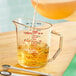 A Cambro clear polycarbonate measuring cup filled with liquid.