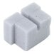 A close-up of a gray square foam block with two holes.