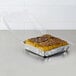 A Dart clear plastic container with a cinnamon roll inside.