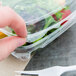 A person holding a Dart ClearPac plastic container filled with salad and a fork.