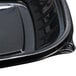 A Dart black plastic bowl with a lid on a table.
