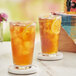 A pair of glasses of Bromley decaffeinated iced tea with lemons on a table.