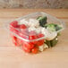 A Dart ClearPac plastic container filled with broccoli, cauliflower, and tomatoes.