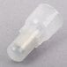 A white plastic crimp connector with a small hole in it.