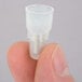 A person's finger crimping a plastic tube using a white Waring crimp connector.