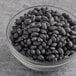 A glass bowl of dried black beans.