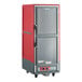 A red insulated full size hot holding cabinet with clear Dutch doors and universal wire slides on wheels.
