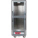 A gray Metro C5 hot holding cabinet with clear Dutch doors and shelves.