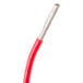A close-up of a red electrical cable with a silver wire on it.