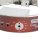 A white rectangular base with a red and white circular metal design.