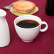 A white Arcoroc vintage coffee cup and saucer on a table.