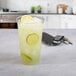 A Solo Ultra Clear plastic cup of lemonade with ice and lime slices on a counter.