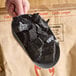 A metal scoop filled with chunks of natural hardwood lump charcoal.