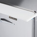 The right hinged stainless steel door of a Traulsen sandwich prep refrigerator on a white counter.