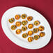 A Tuxton Alaska china serving platter with mini cheese and pepper tarts.