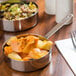 A table with a pot of food in an American Metalcraft mini stainless steel fry pan.