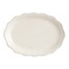 An ivory stoneware oval platter with a scalloped edge.