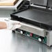 A person wearing gloves holds a Waring drip tray over a counter.