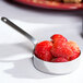 A stainless steel American Metalcraft mini fry pan filled with strawberries on a table.