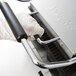A person in gloves using a Waring panini grill handle.