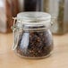 An American Metalcraft glass miniature apothecary jar with cloves inside.