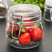 An American Metalcraft glass apothecary jar filled with strawberries.