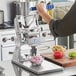 A person using an Edlund Titan Max-Cut Manual Dicer to chop vegetables.