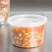 A clear Solo polypropylene container with food inside.