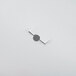 A metal Waring motor shroud on a white surface with a hole in a piece of paper.